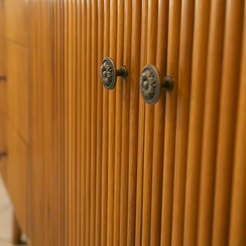 Close-up of fluted teak doors and antique brass knobs