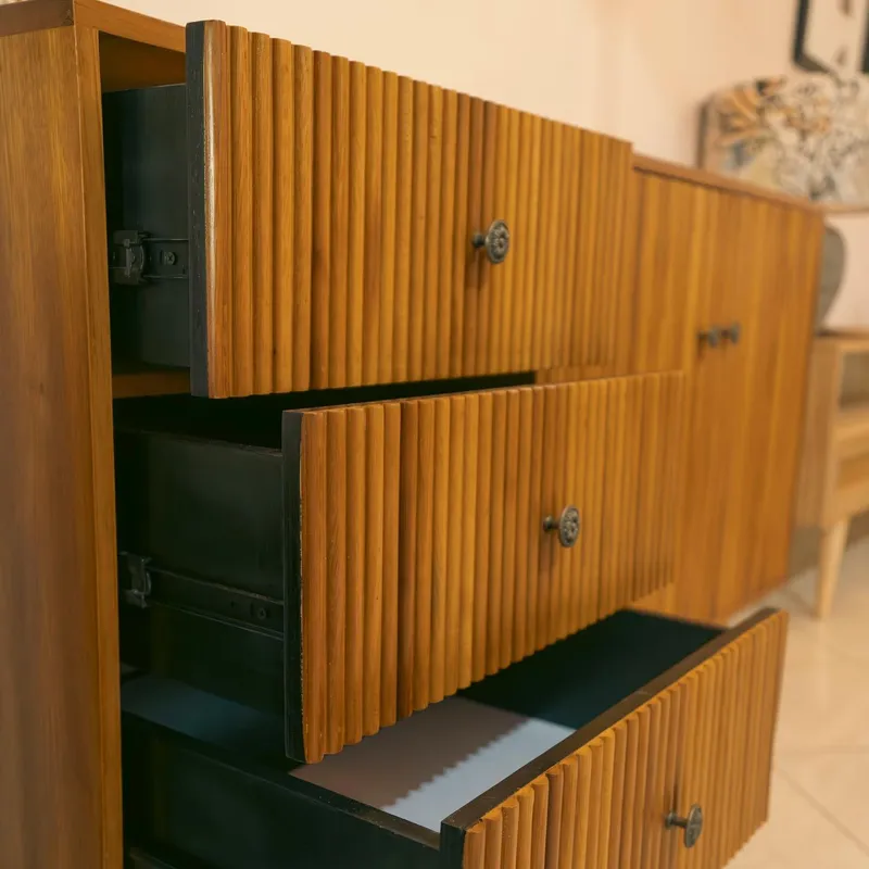 Open drawers of a fluted teak sideboard