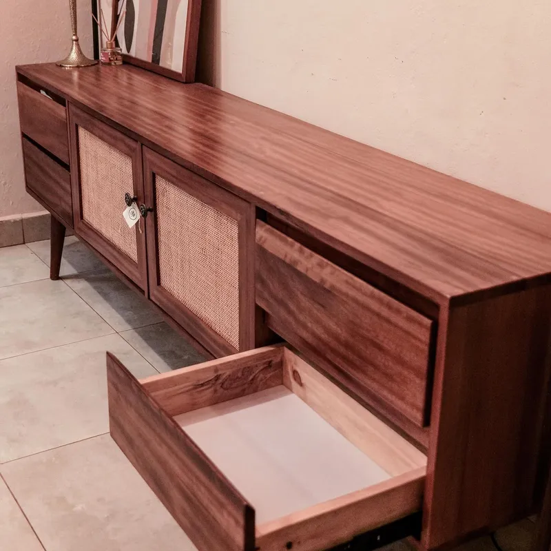 Long mahogany console with cane doors and an open drawer