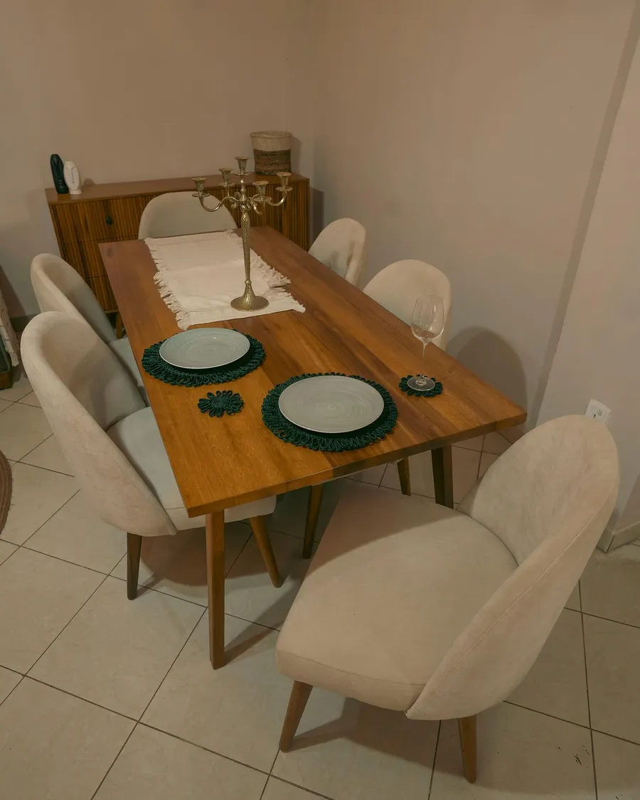 Teak dining table set for two with upholstered chairs and a fluted sideboard