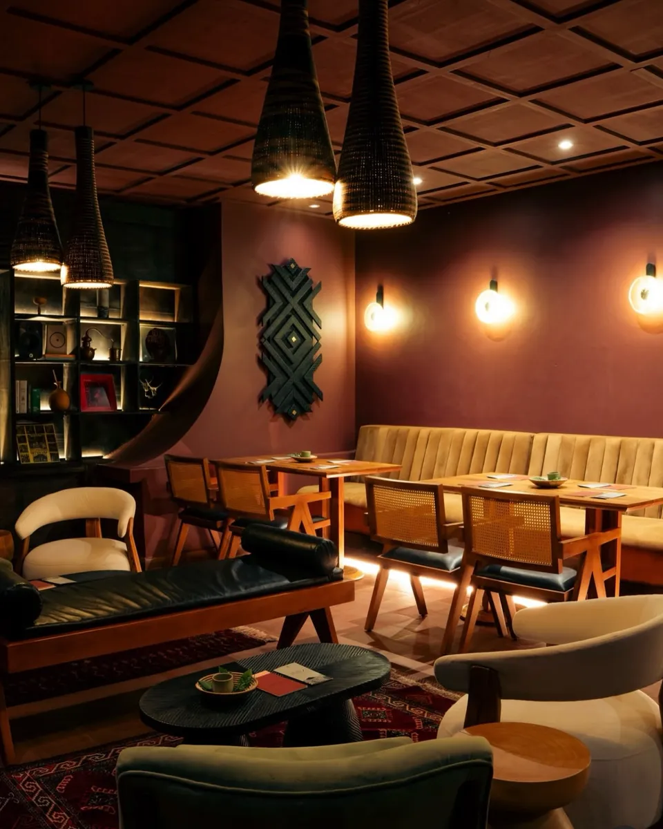 Restaurant lounge with cane chairs, a banquette and woven pendant lights