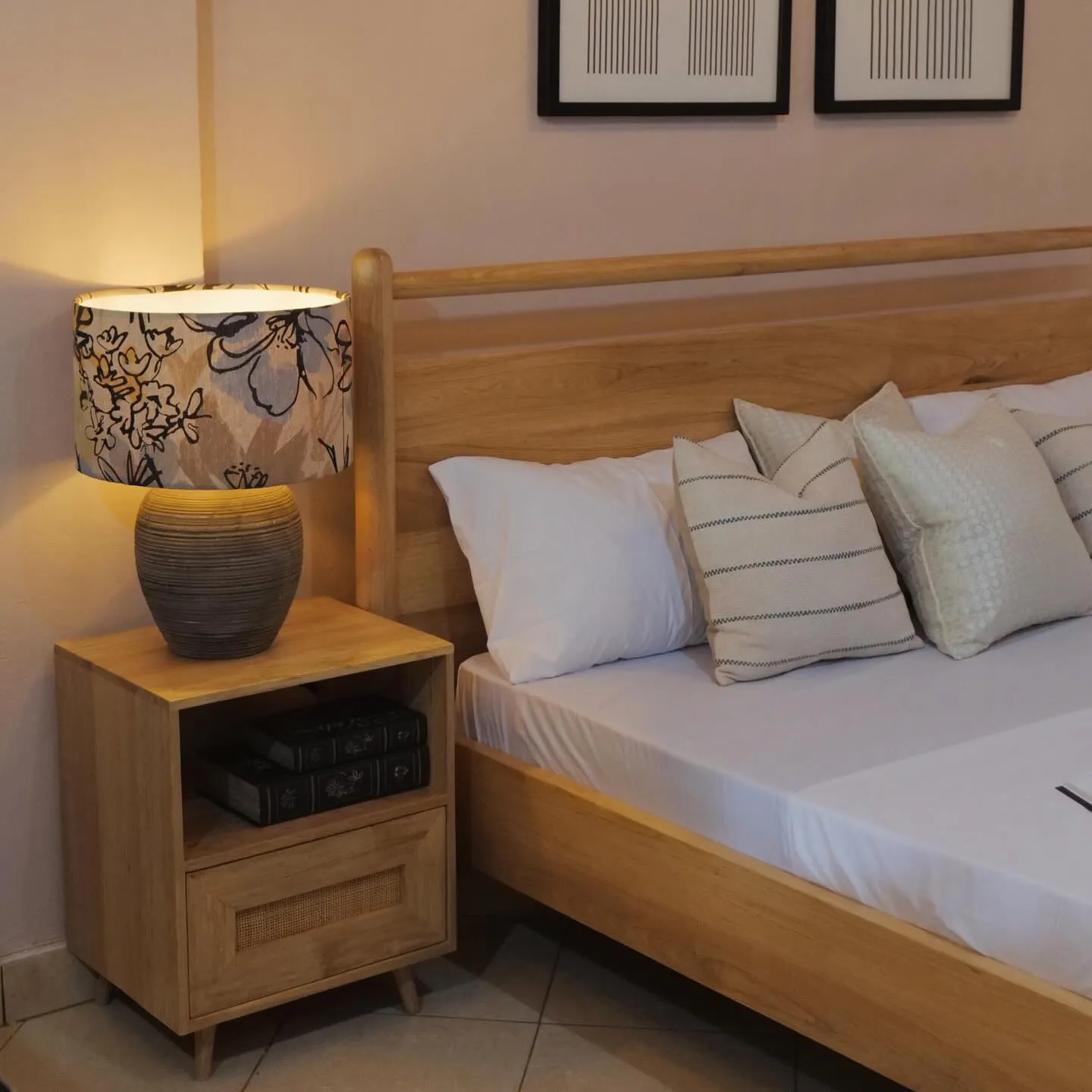 Oak bed and bedside table with a cane drawer under a lit lamp